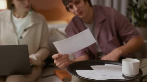 Young Couple Reviewing Bills Together at Home at Night