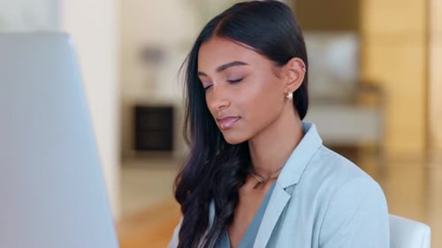 Stressed business woman suffering from a headache or migraine while working late at the office