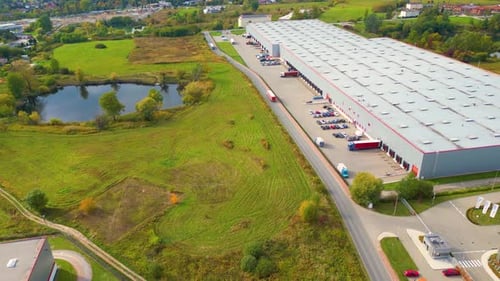 Aerial view of a semi trucks with cargo trailers standing on warehouses ramps for loading unloading