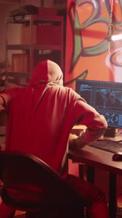 Person Typing Code on Computer in Dark Room