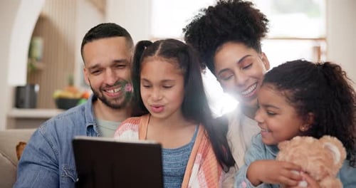 Happy Family Using Tablet Together on Couch at Home