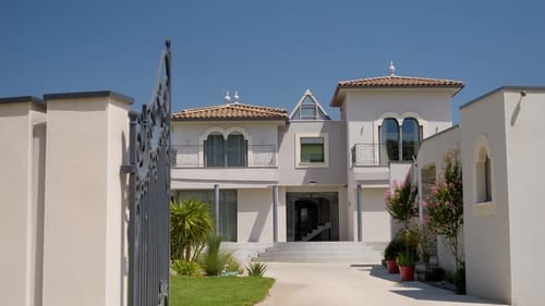 Traveling shot of a magnificent luxurious Moroccan house, in the foreground the wrought iron gate, t