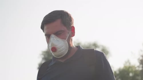 Man Fumigating Field with Mask in Sunlight Flare