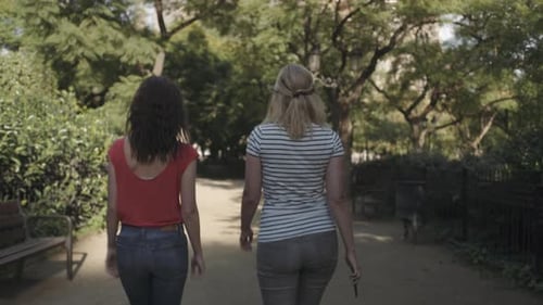 Young adult women on vacation walking in park