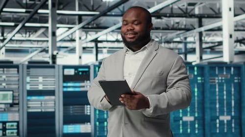 Cheerful Data Center Programmer Looking at Code Debugging Tools on Tablet