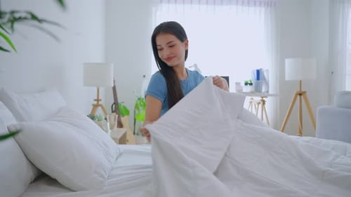 Woman Waking Up and Stretching in Bright Bedroom