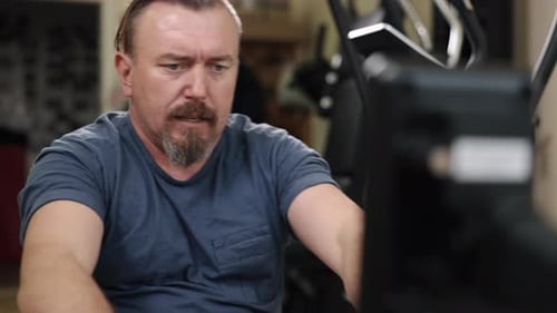 Man Working out on Rowing Machine at Home