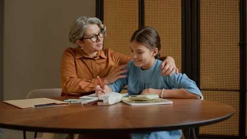 Granny Supporting Young Girl Ding Homework in Apartment