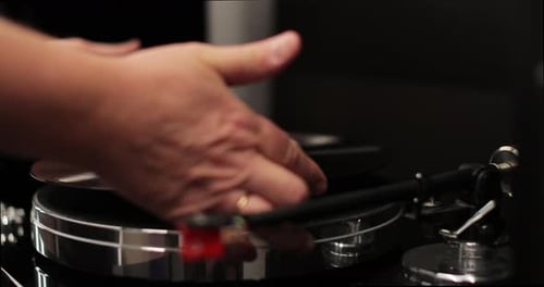 Hand Placing Vinyl Record on Turntable, Close Up