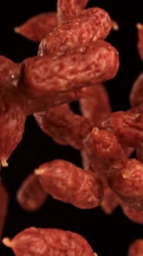 Mini Salami Fly and Fall on a Black Background Filmed on a Highspeed Camera at 1000 Fps