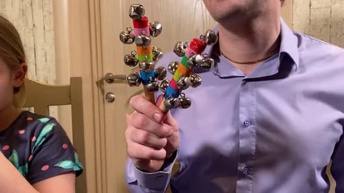 Man Playing Jingle Bell Toy for Child