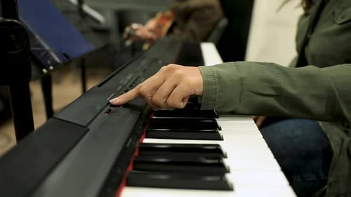 Female hands tuning the piano to play on it in the studio - close up