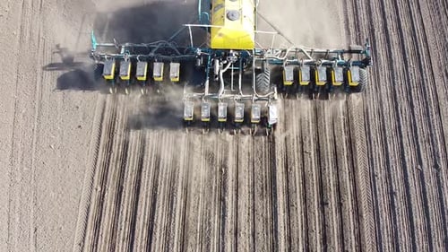 Tractor with yellow seeder working on the field in Ukraine OA Lexa