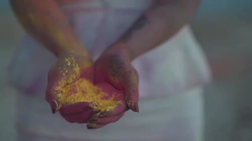 Close Up Slowmotion of Ring Falling Into Female Hands Full of Colorful Powder. Holi Festival and Wed