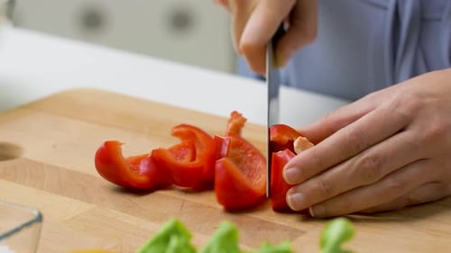 Hands Slicing Red Bell Pepper for Healthy Meal