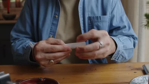 Bearded Man Making Roll-Up Cigarette at Home
