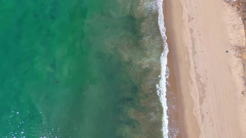 Beautiful turquoise water of the sea rolls the waves to the shore.