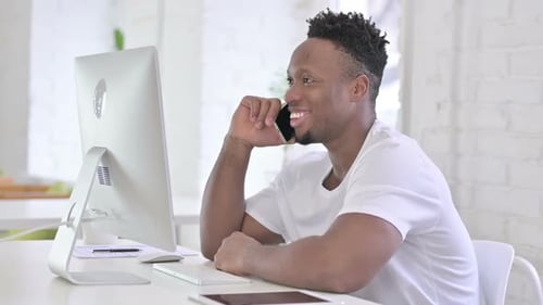 Serious Casual African Man Talking on Smartphone in Office