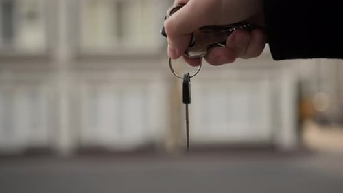 Close-up - the key to the new apartment in the hands of a man, buying a new apartment