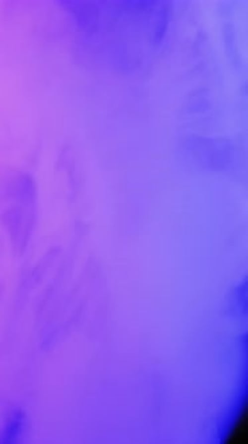 Blue and purple ink drops and spreads in water