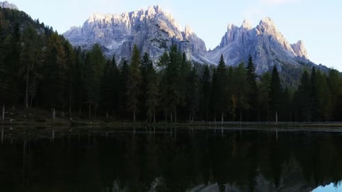 Blooming algae. Autumn landscape with clear lake, fir forest and majestic mountains