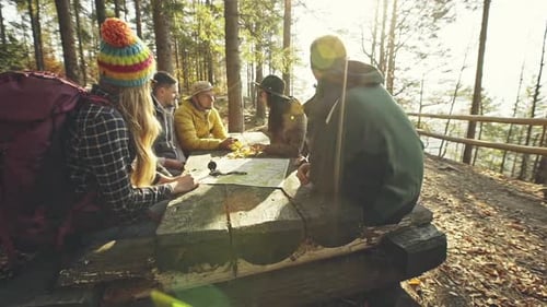 Hikers Planning Route at Table in Woods