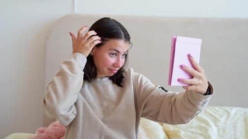 Junge Frau, die sich Sorgen macht, dass Akneentzündungen und Aknenarben auf ihrem Gesicht auftreten, junges Mädchen