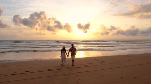 Couple of Men and Woman on the Beach at Sunset By the Ocean of Phuket Thailand
