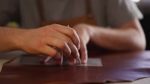 Hands Crafting Leather with a Sharp Tool