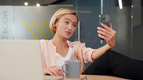 Office Worker on Mobile Video Call Emphasizes Remote Teamwork for Tech Projects