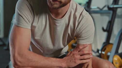 Closeup Footage of Focused Young Attractive Bearded Man Doing Exercises with Dumbbells Guy in Tshirt