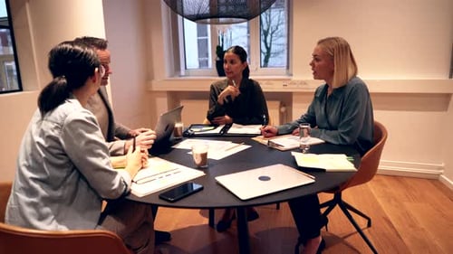 Team Discussing Business Around Conference Table