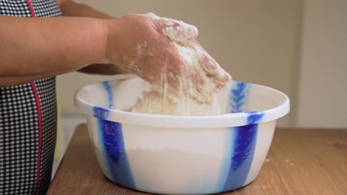 Stretching Dough with Hands Over Bowl Unrecognizable Person Pulling Mixture in Container Working