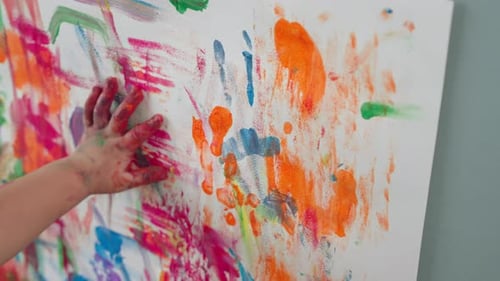 Asian Little boy enjoy colorful painting on paper with roller