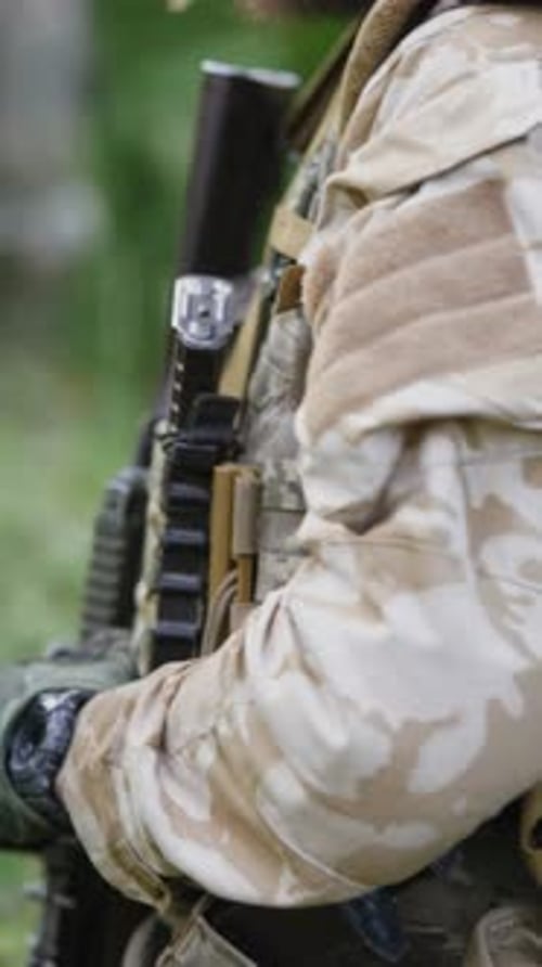 Soldier in Camouflage Walking With Weapon Through Forest
