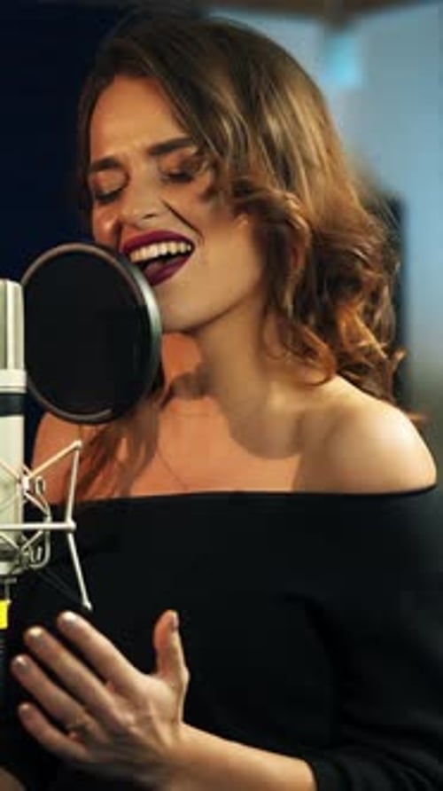 Beautiful young singer who recorded a song in a professional recording studio.
