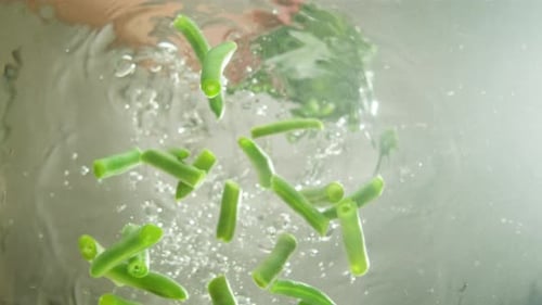Gefrorenes Gemüse, grüne Bohnen, Nadelbohnen, die in kochendes Wasser fallen, frisches Obst und