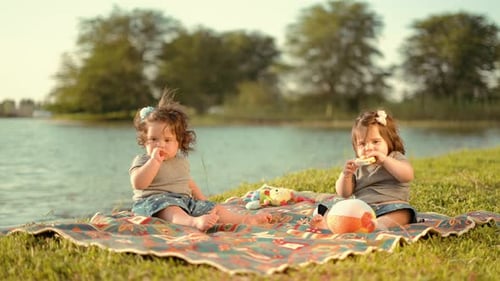 Twin Babies Seating and Playing in the Lake
