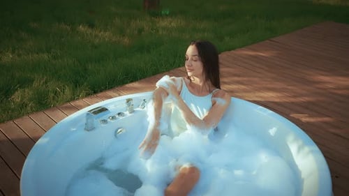 Woman Enjoying Bubble Bath in Tropical Outdoor Hot Tub