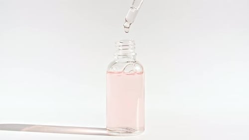 Serum Dropping Into Glass Bottle