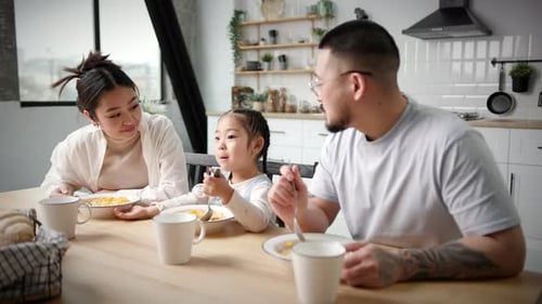 Family Eating Breakfast Together at Kitchen Table