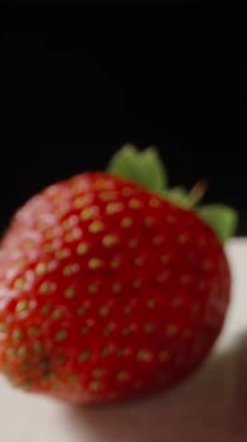 Strawberries and red jelly on a white plate. On a black background. Dolly slider extreme close-up. V