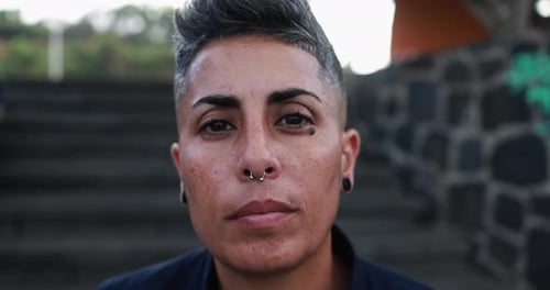Happy gay woman looks directly at the camera during a pride parade in the city