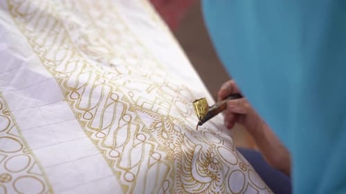 La técnica de hacer batik dibujado a mano con una herramienta de inclinación. Este artesano está haciendo batik typica