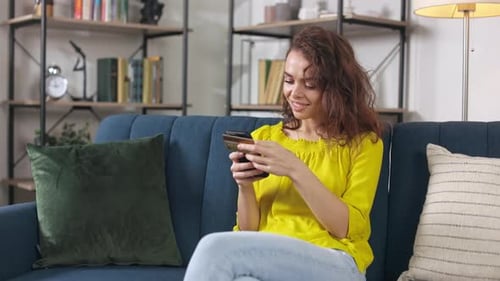 Woman on Couch Using Phone at Home