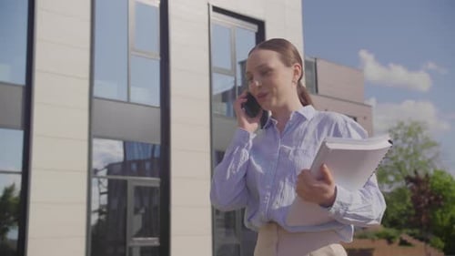 Businesswoman Talking on Phone Outside Office Building