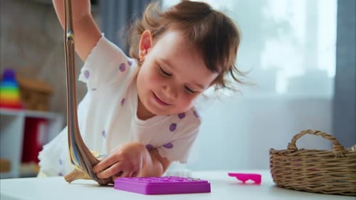 Young Girl Playfully Stretching Colorful Putty at Home