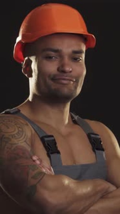 Confident Muscular African Male Builder in Hardhat Giving a Thumbs Up