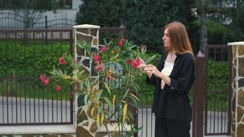 Alone Beautiful Young Woman Enjoying Beautiful Flowers in Her Garden Near Her House
