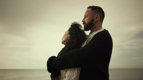 Lovers Enjoying Sea Beach Sunset. Mixed Race Couple Embracing On Ocean Shore. Man Hugging Woman O...